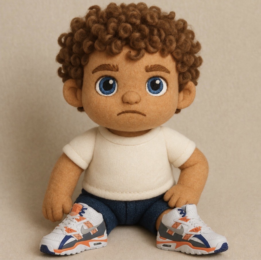 Plushie Johnny — curly-haired plush boy with bright blue eyes, a white tee and his own trainers